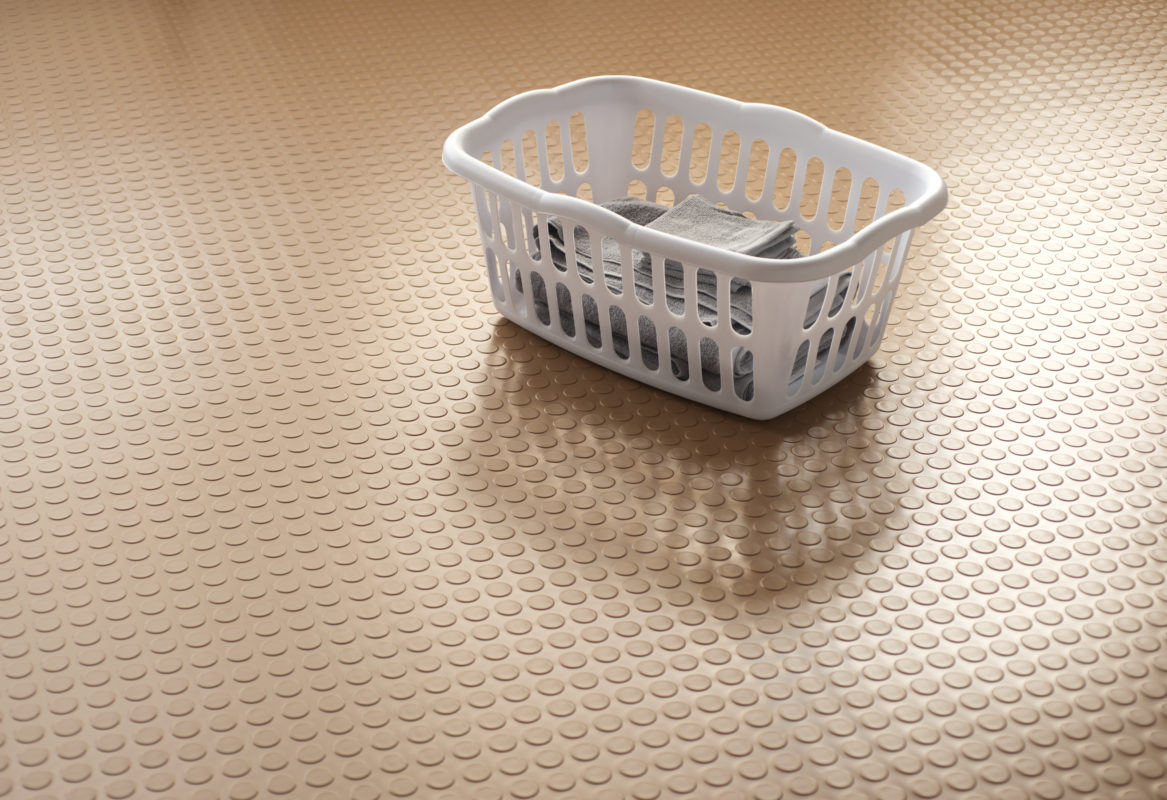 sandstone tan large coin vinyl flooing with white laundry basket