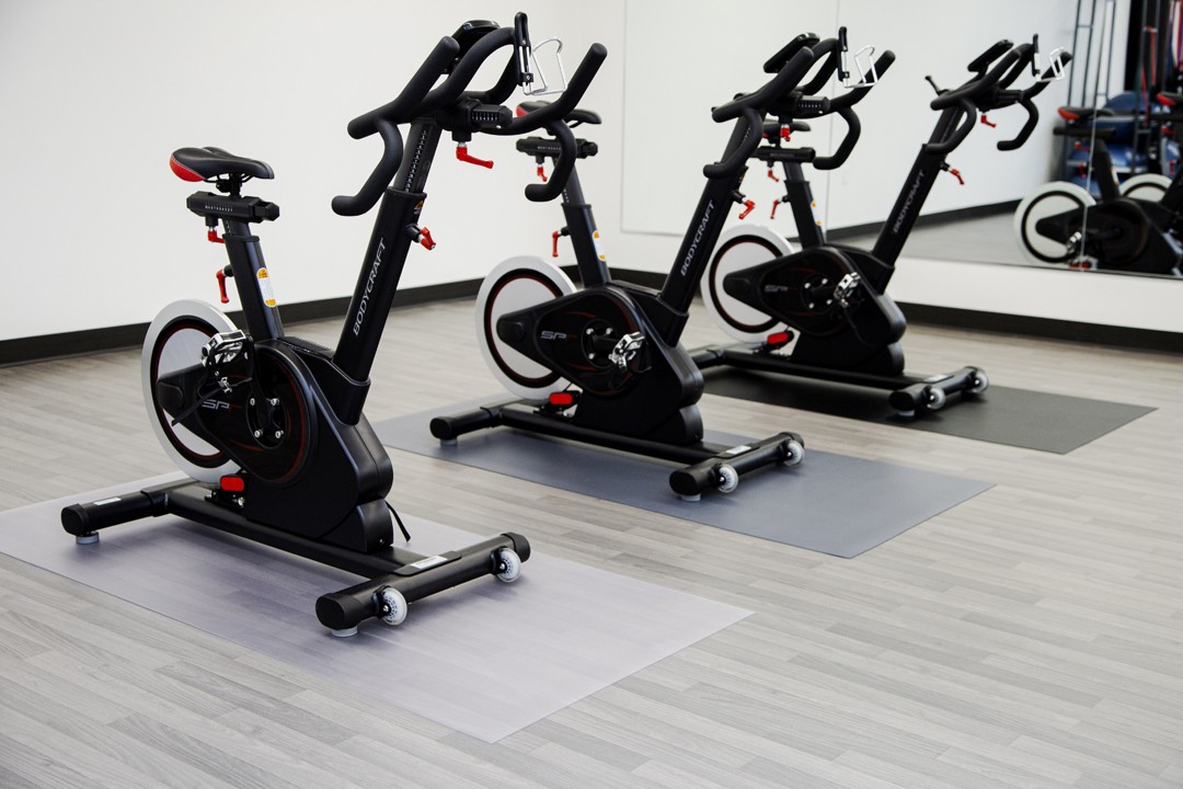Exercise bike on waterproof protecting mat in a gym
