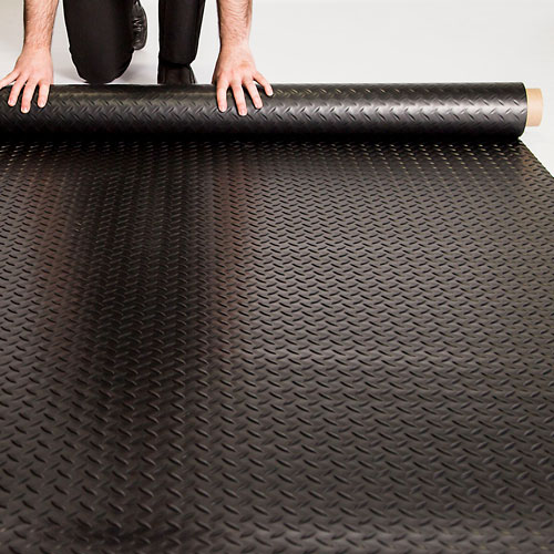 man unrolling G-Floor black diamond tread flooring