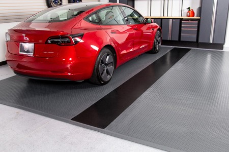 Red Tesla on grey diamond tread flooring with black ribbed G-Floor runner