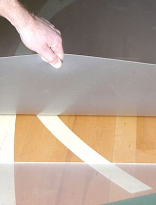lifting up the edge of clear gym floor covering
