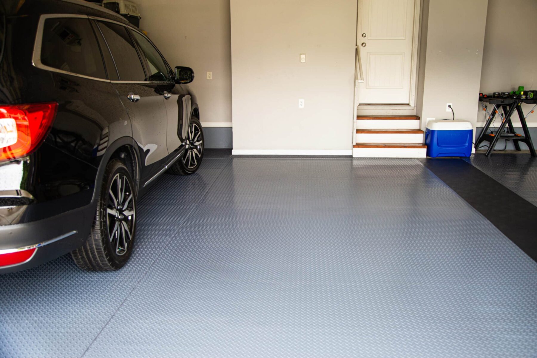 Slate Grey G-Floor vinyl flooring in a garage with a black SUV